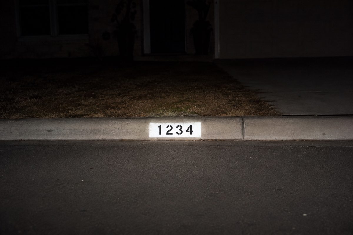 Illustration of a reflective curb number lit by headlights at night